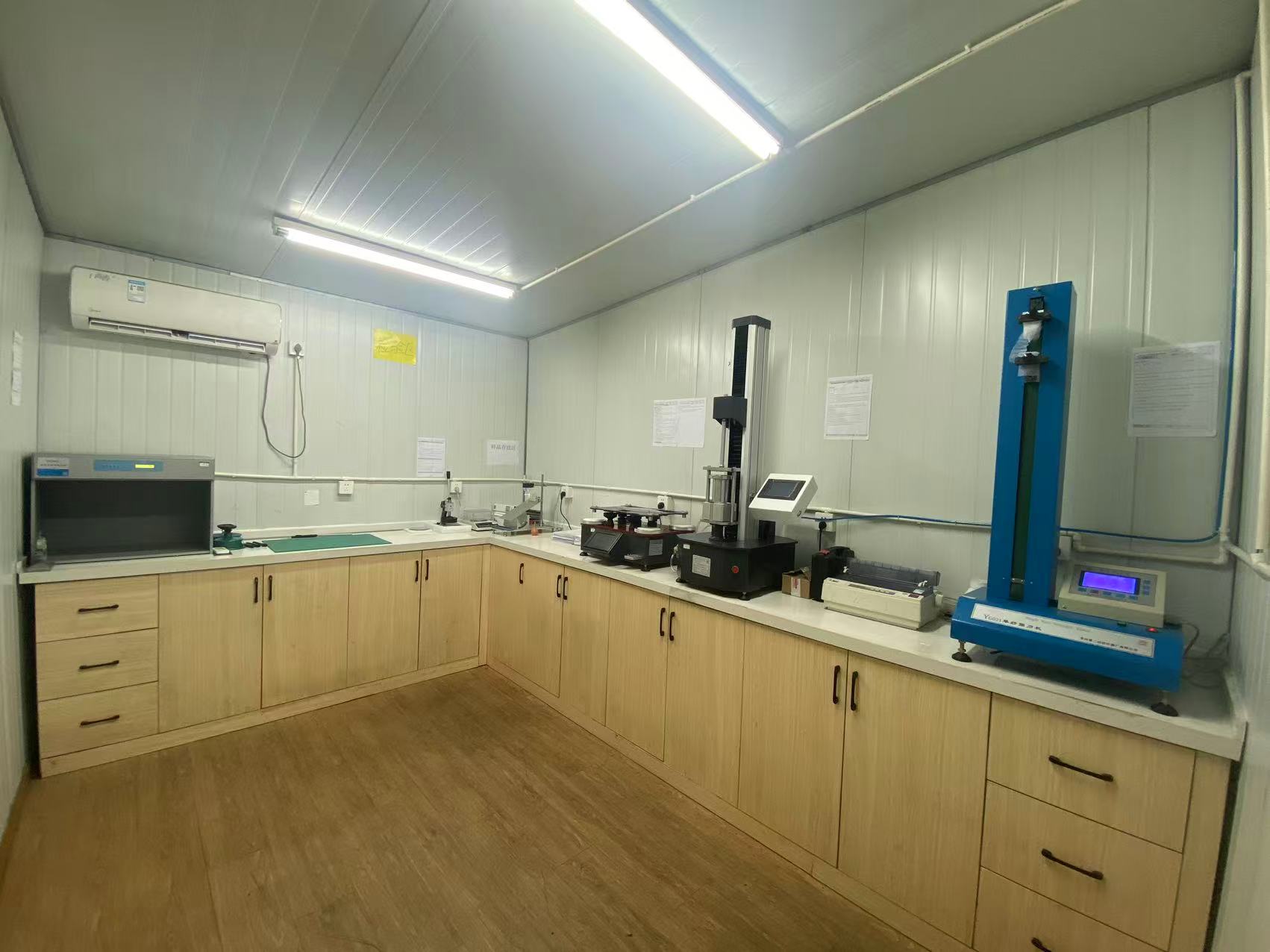 In-house testing room with fabric testing instruments and a color assessment cabinet
